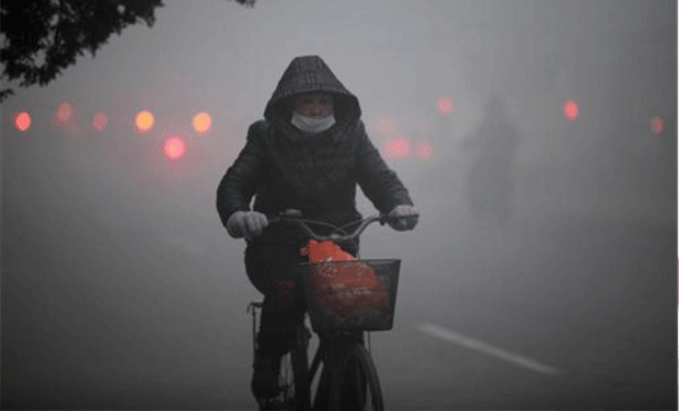 A cyclist wearing a mask in Beijing. (Photo-AP) A cyclist wearing a mask in Beijing. (Photo-AP)